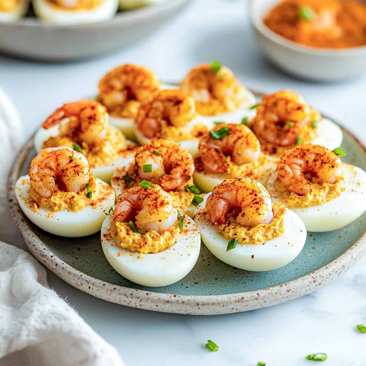 Side view of cajun shrimp deviled eggs on a blue plate.