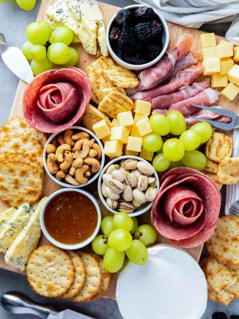 Classic charcuterie board on a grey surface.