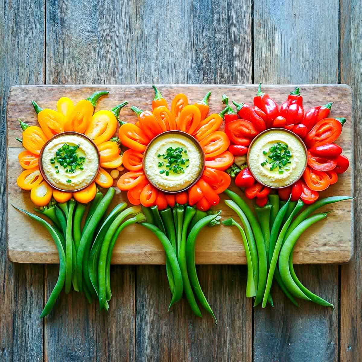 Vegetables arranged like flowers and served with dip.