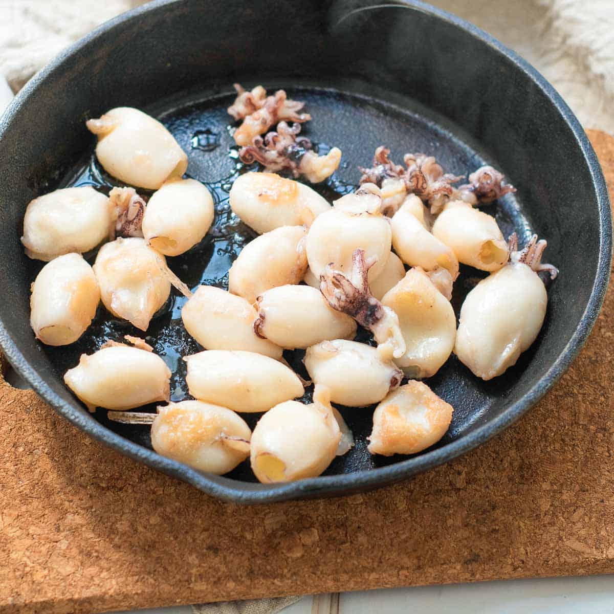 Cooked calamari in a skillet.