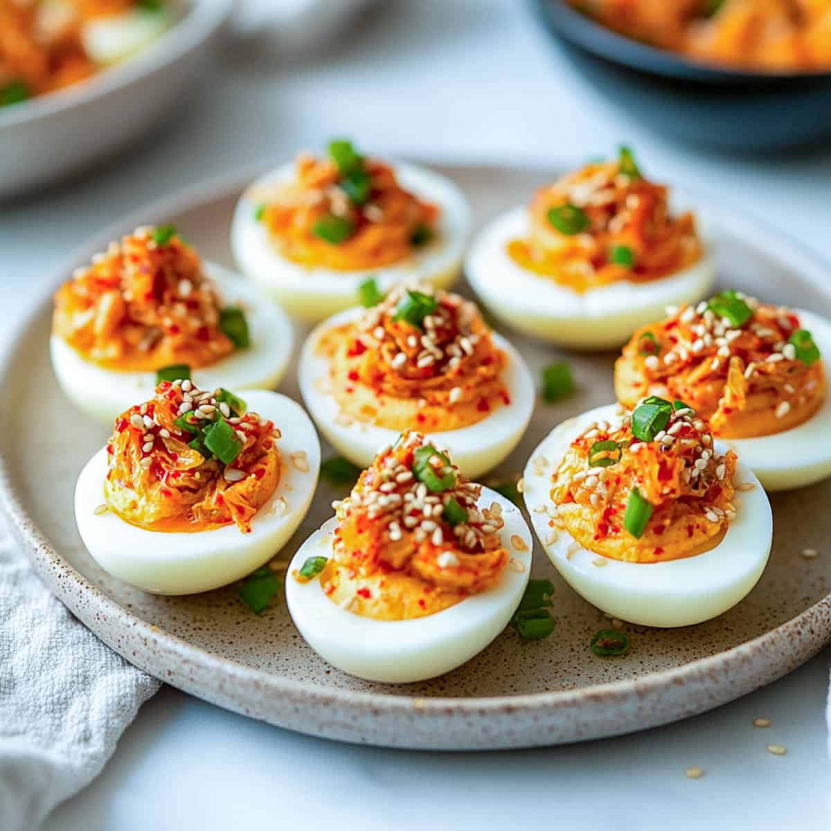 Side view of kimchi deviled eggs on a serving plate.