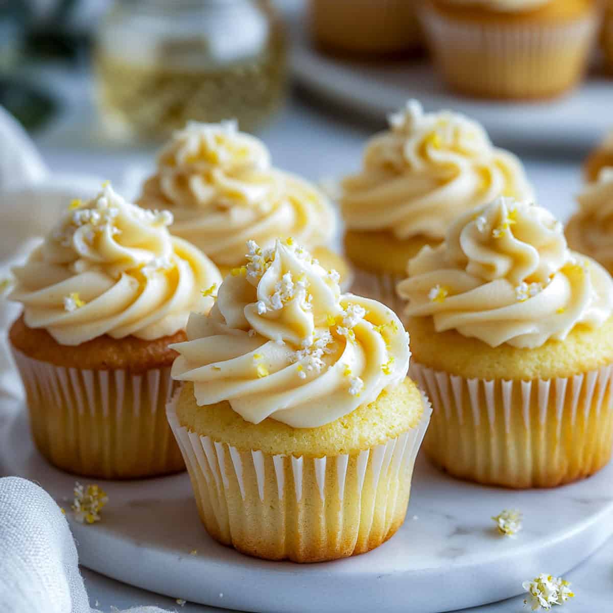 Lemon elderflower cupcakes placed on a marble board.