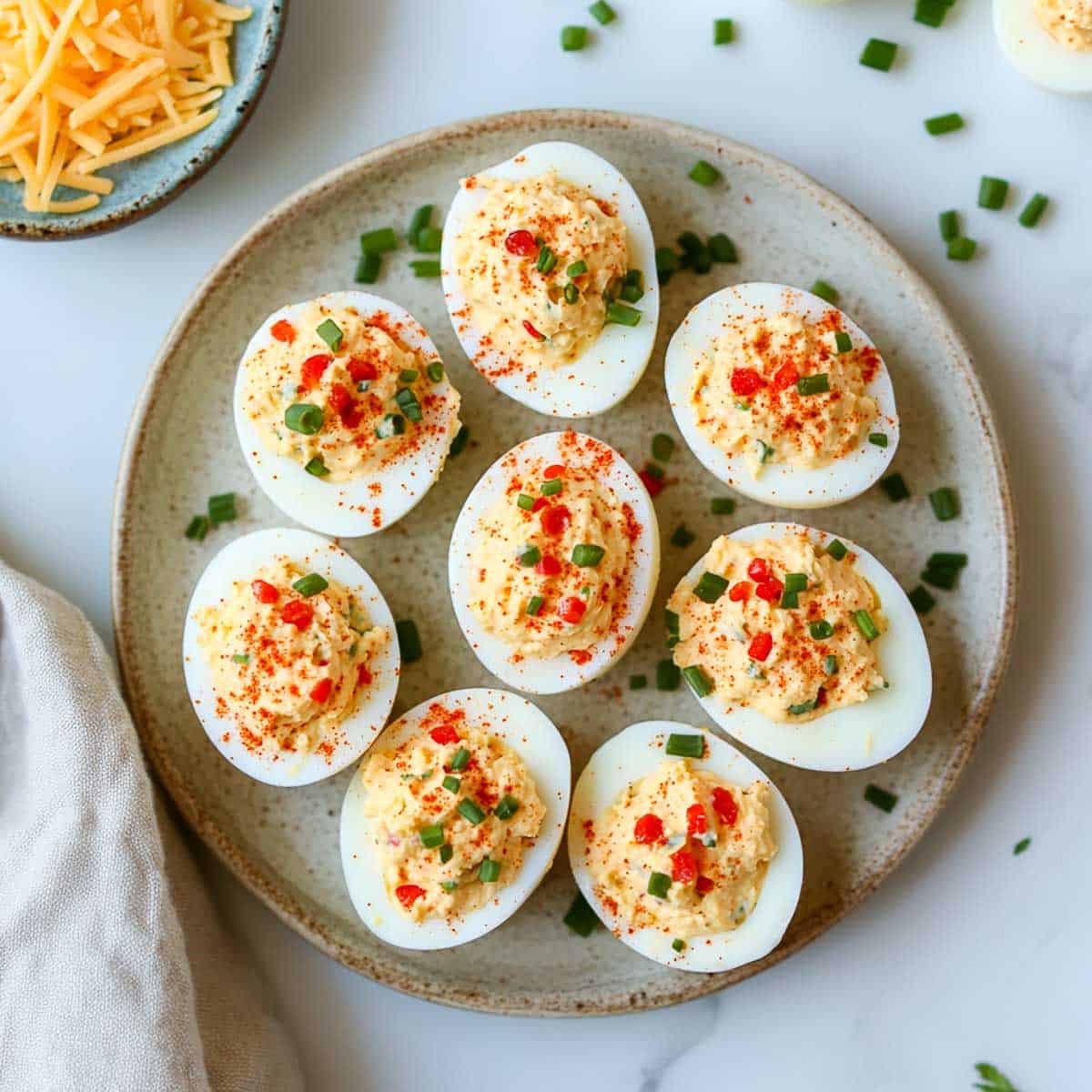 Deviled eggs garnished with pimento and cheese.