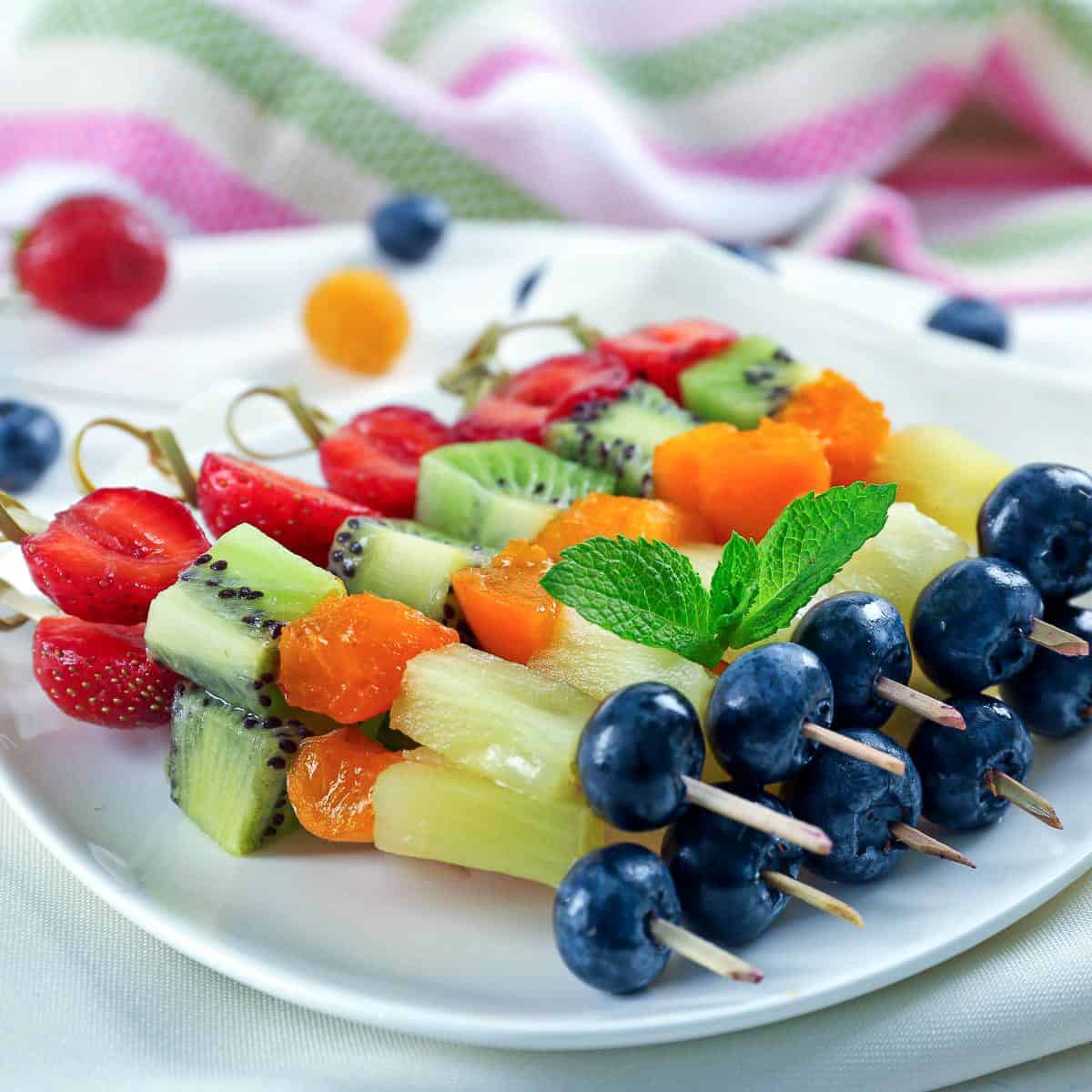 Fruit skewers on a serving plate.