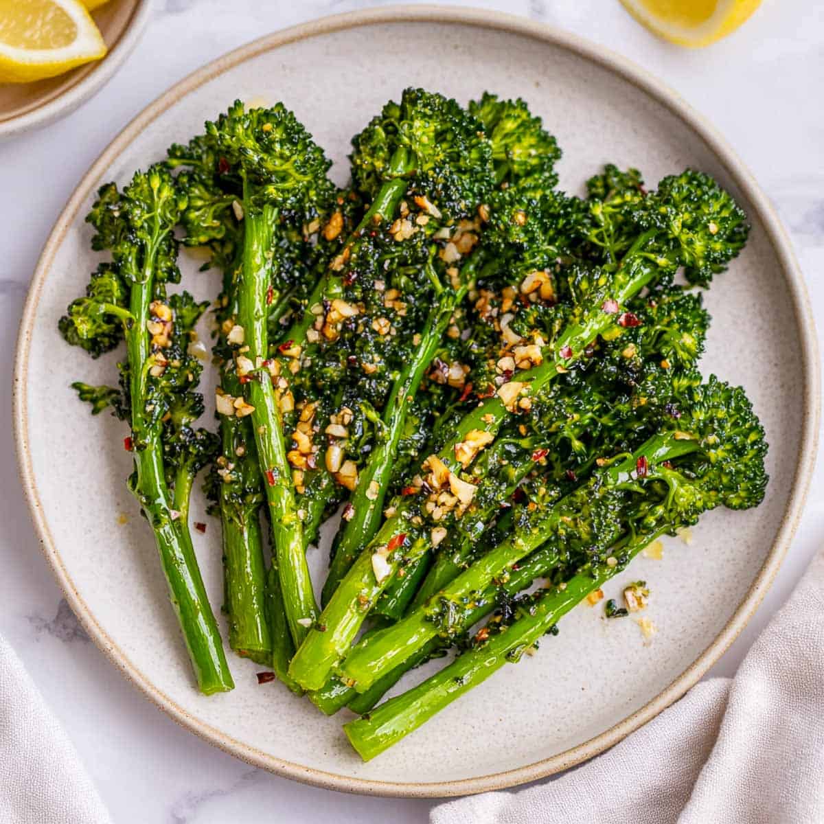 Sauteed garlic broccolini on a white serving plate.