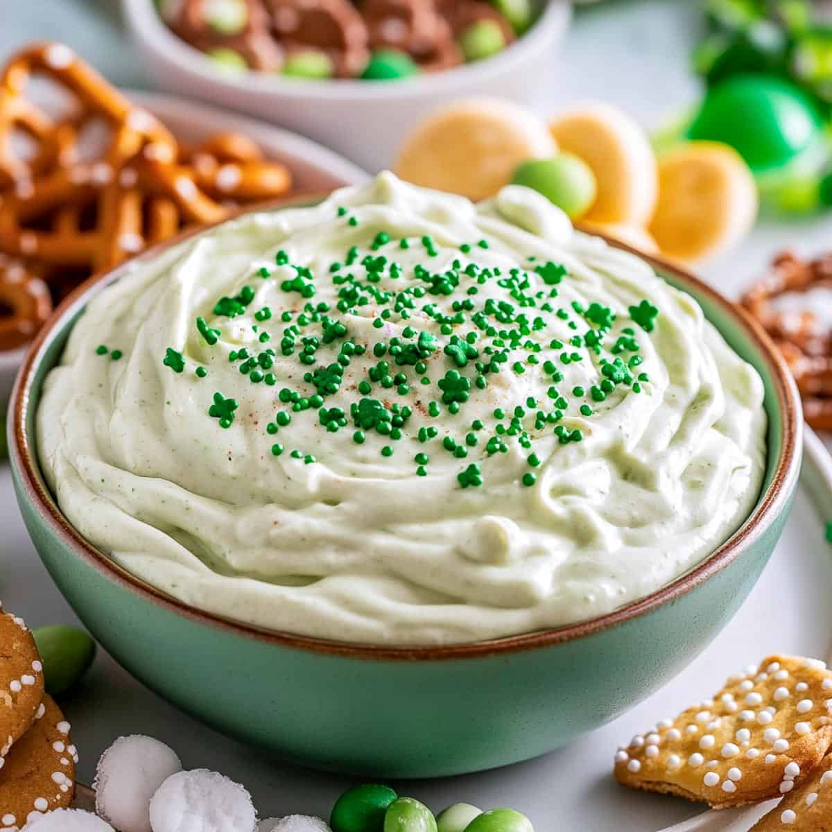 Shamrock sugar cookie dip in a green bowl.