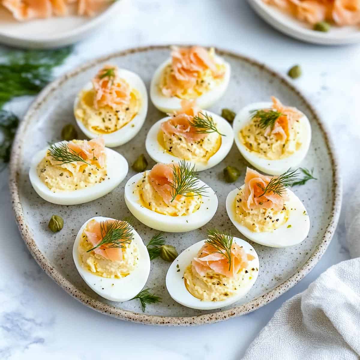 Side view of smoked salmon deviled eggs with smoked salmon in the background.