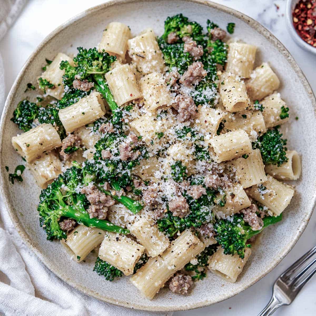 Sausage and broccolini pasta on a serving plate.