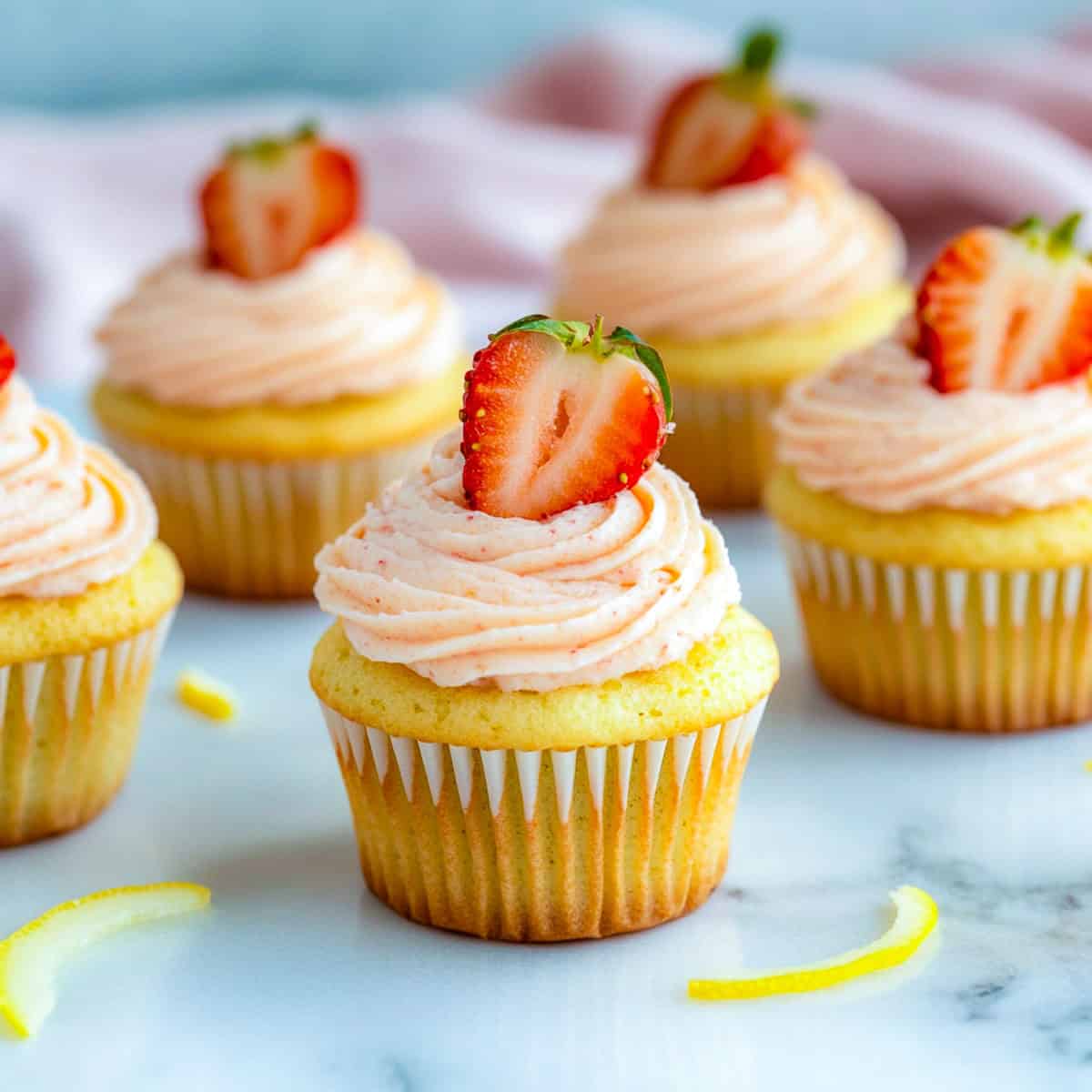 Strawberry lemonade cupcakes topped with strawberry slices.