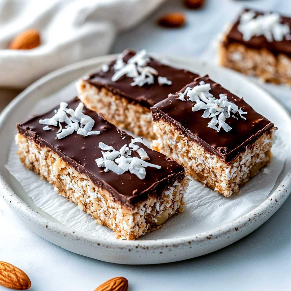 Almond and chocolate protein bars topped with shredded coconut.