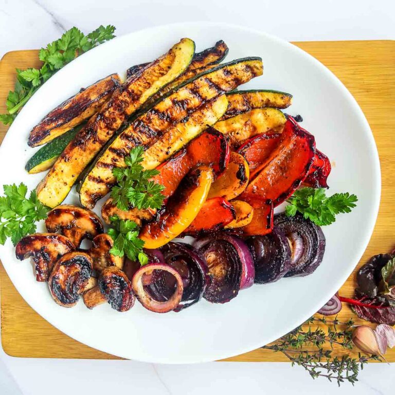 Side view of balsamic glazed veggie platter placed on a wooden board.