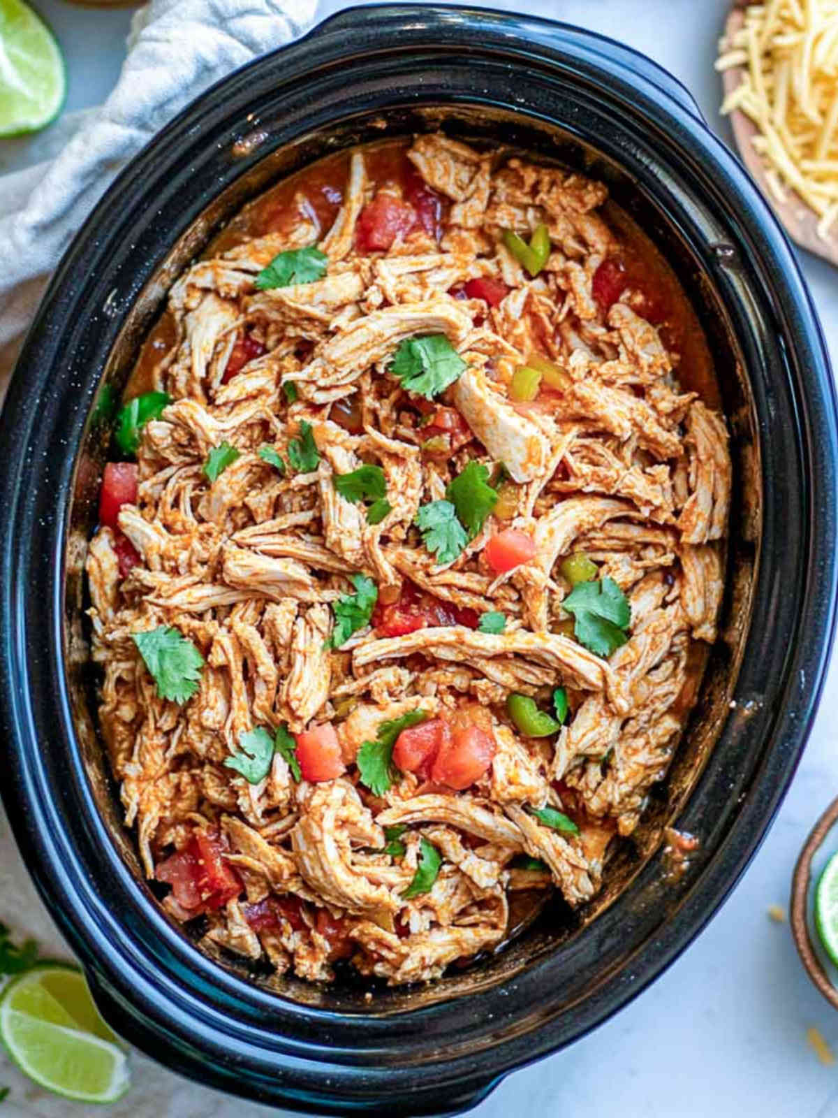 Slow-cooked chicken in a tomato and spice mixture, shredded and ready for tacos.