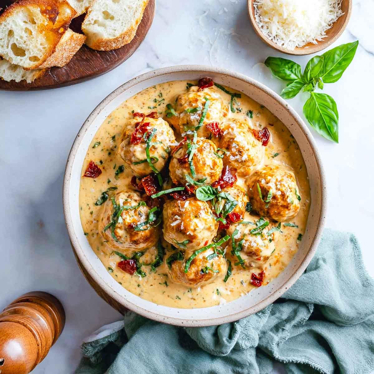 Chicken meatballs in creamy tomato sauce with basil and crusty bread.