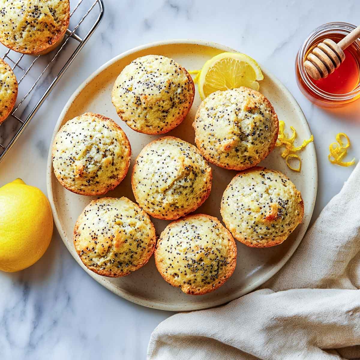 Top-down view of lemon poppy seed muffins with cottage cheese, lemon slices, and honey jar.