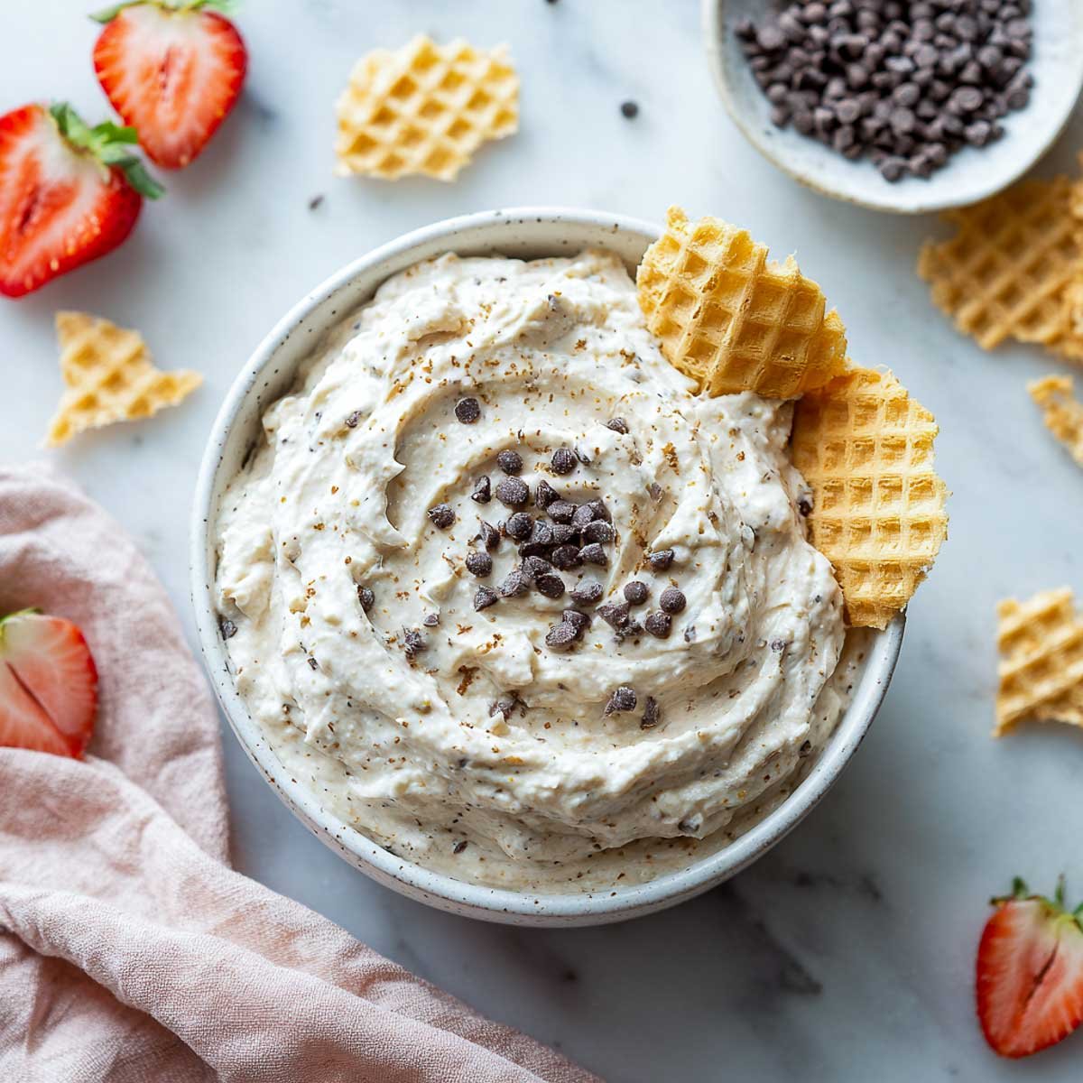 Creamy cannoli dip with mini chocolate chips and waffle cone dippers.