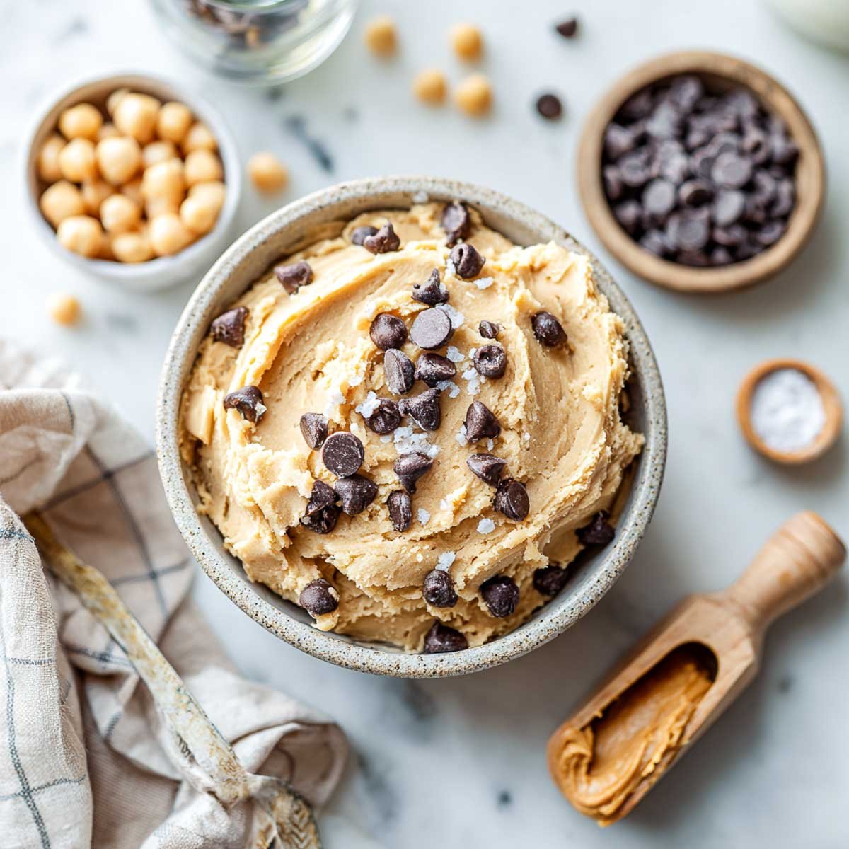 Top-down view of chickpea cookie dough with chocolate chips, salt, and peanut butter.
