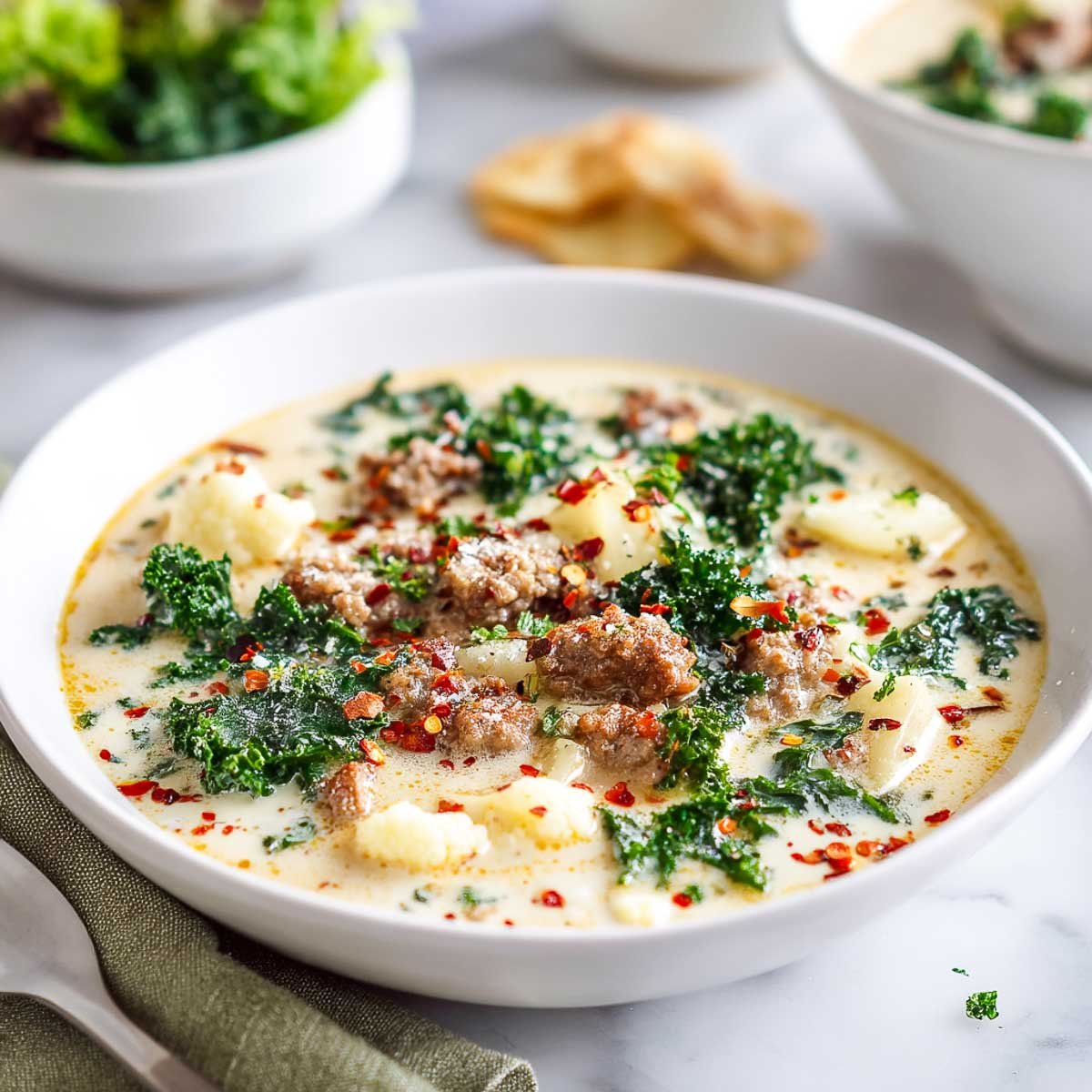Low-carb Zuppa Toscana with cauliflower, kale, and sausage in a creamy broth.