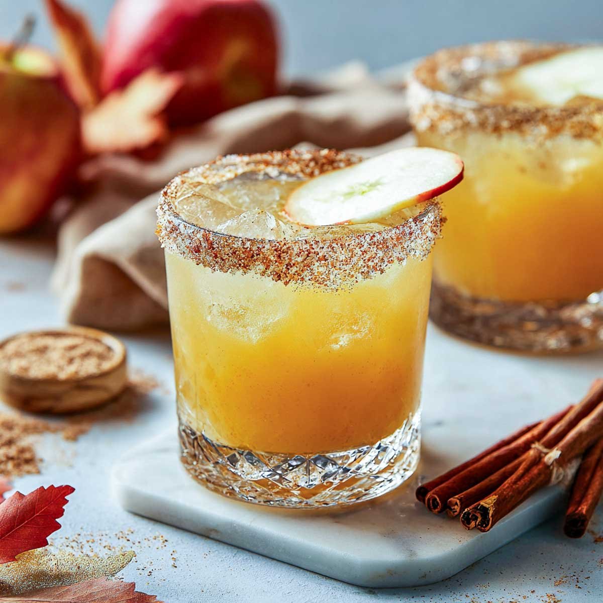 Apple cider margarita with cinnamon sugar rim and apple slice garnish.