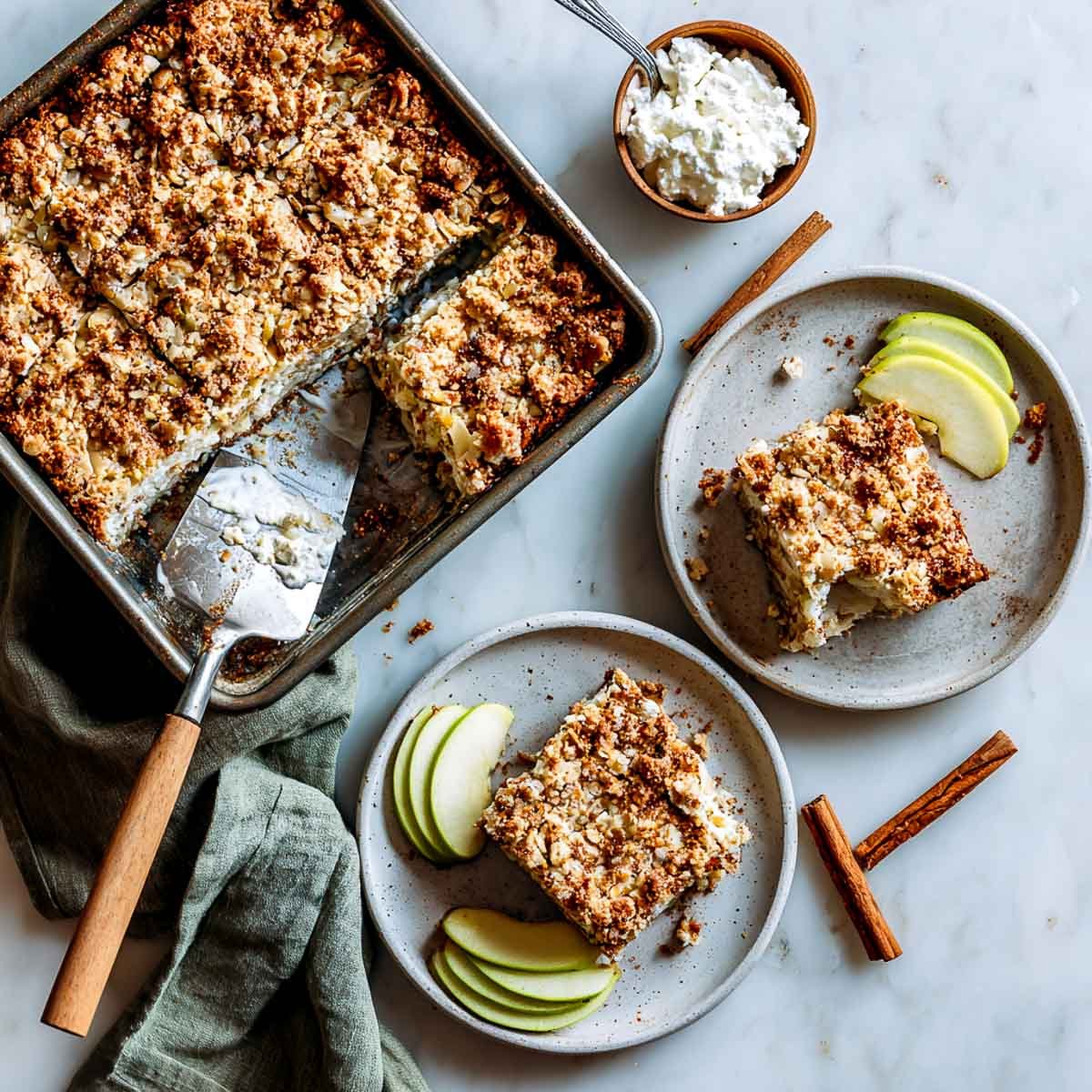 Apple cinnamon cottage cheese bar on ceramic plate with apple slices and crumble.