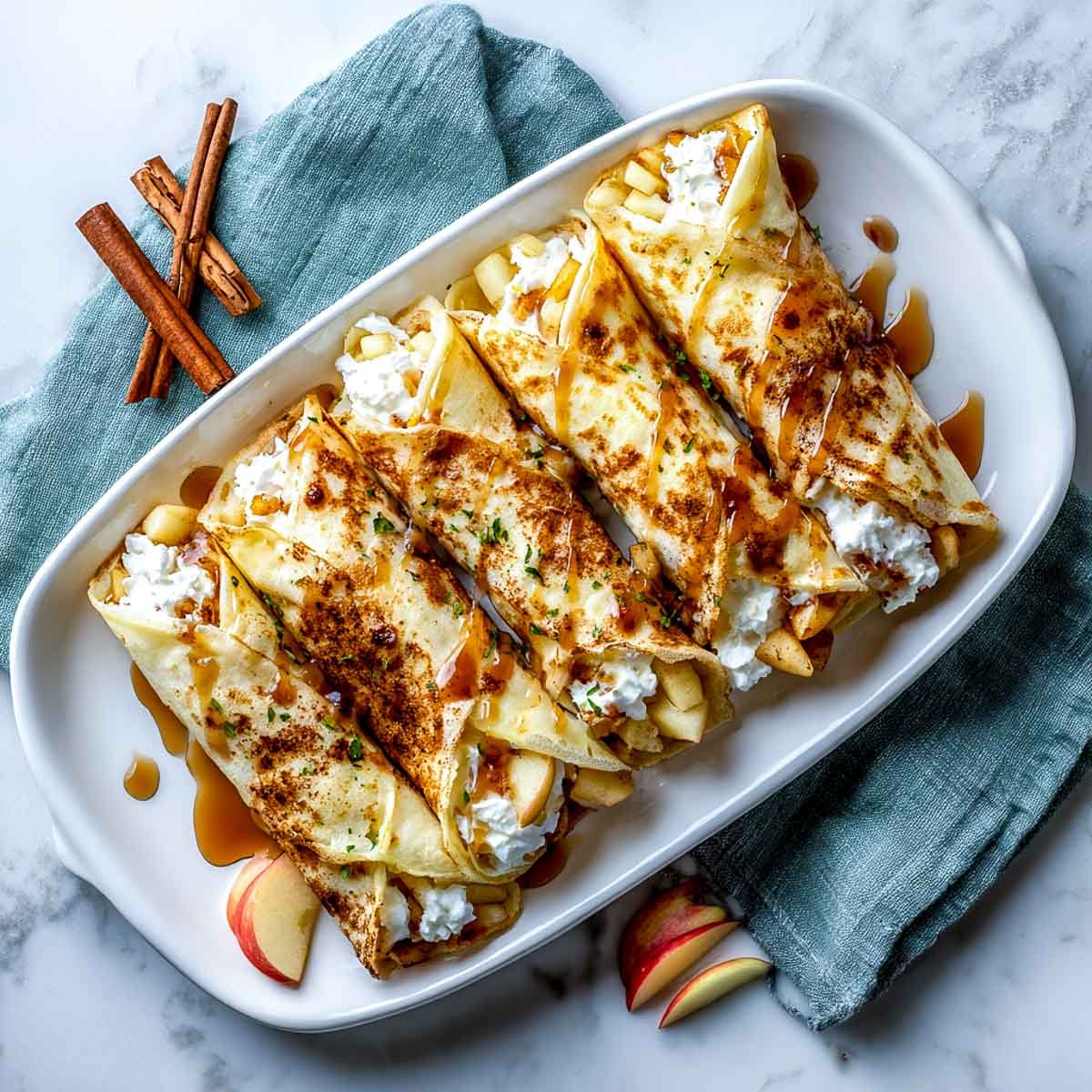 Soft rolled crepes filled with warm spiced apples and cottage cheese, finished with maple syrup.