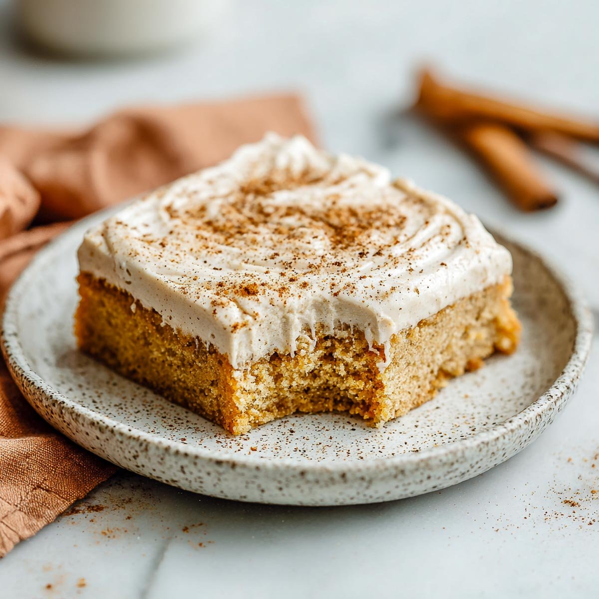 Single chai cookie bar with buttercream and cinnamon, served on ceramic plate.