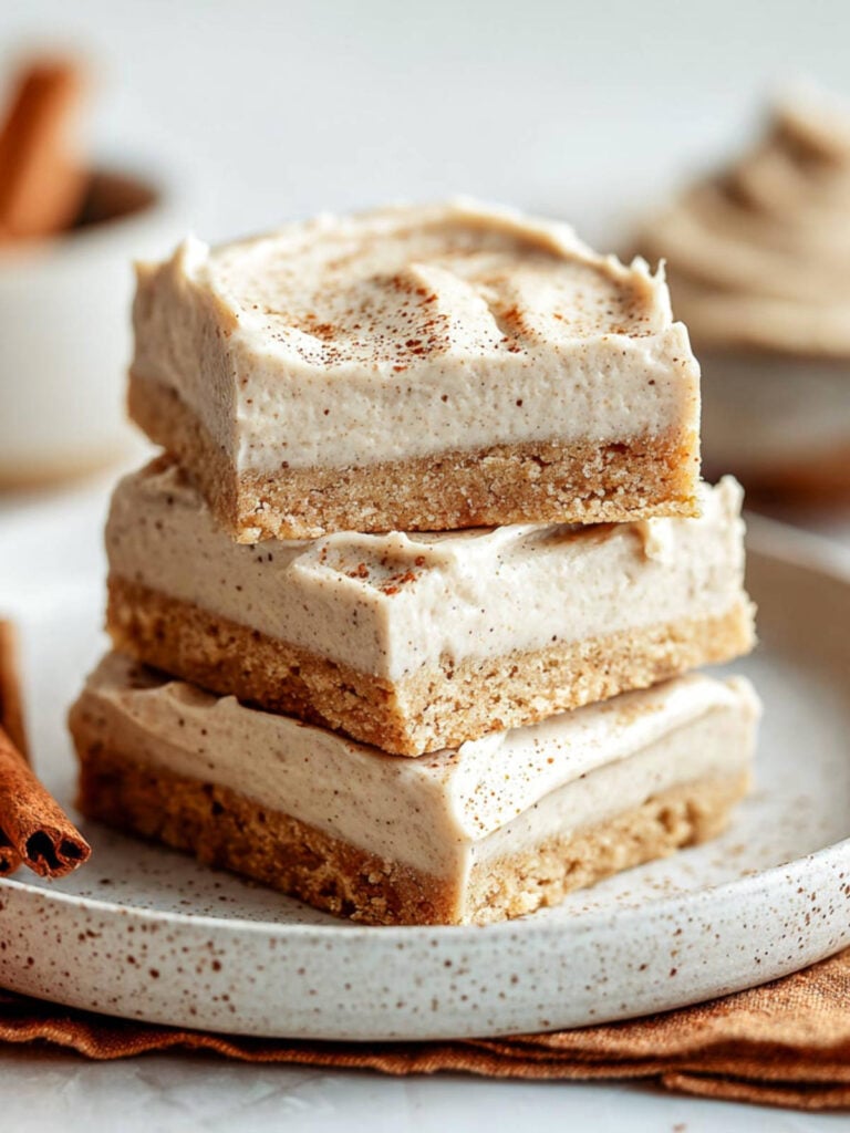 Close-up side view of stacked chai buttercream bars on speckled plate.