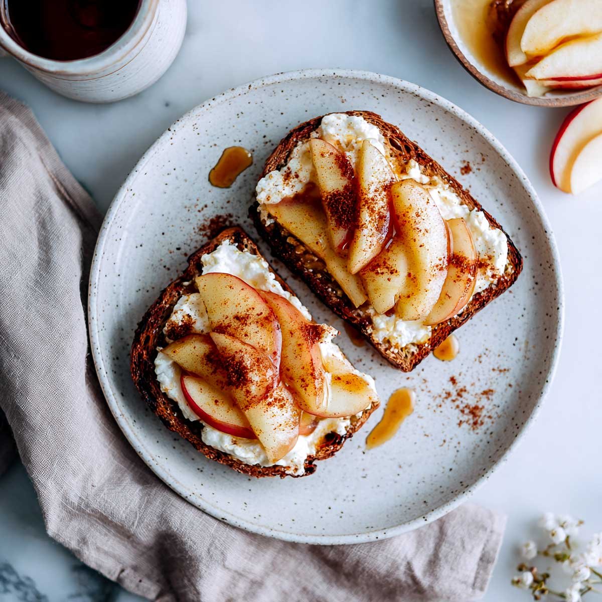 Cinnamon apple toast layered with cottage cheese and maple drizzle.