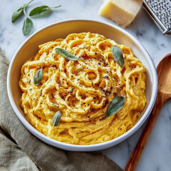 Pumpkin cottage cheese pasta in a white serving bowl.