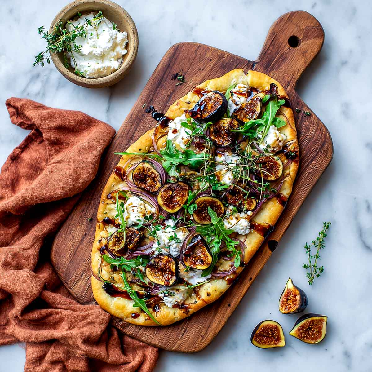 Roasted fig flatbread with cottage cheese, arugula, and balsamic glaze.
