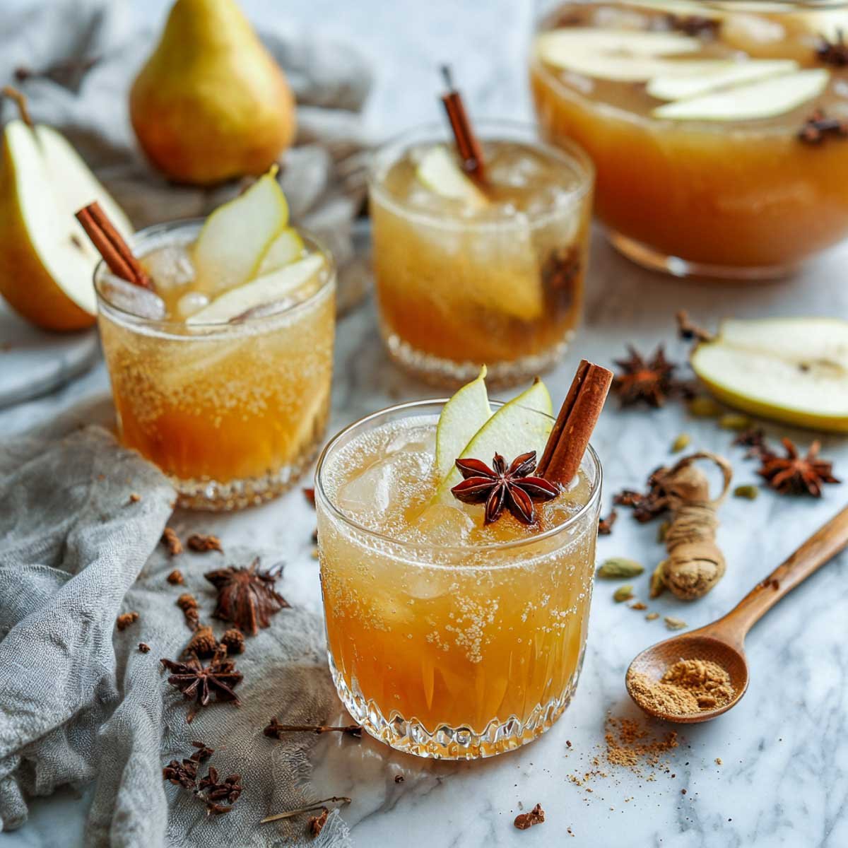 Spiced pear bourbon punch with ice, pear slices, and cinnamon sticks.