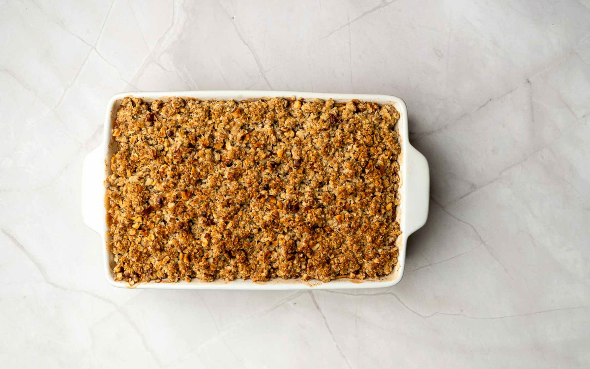 Golden brown apple crisp baked in a dish with a crisp oat topping.