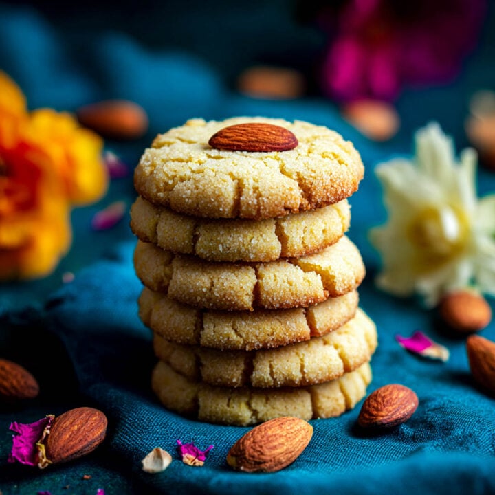 Stack of besan butter cookies made with ghee, topped with almonds.
