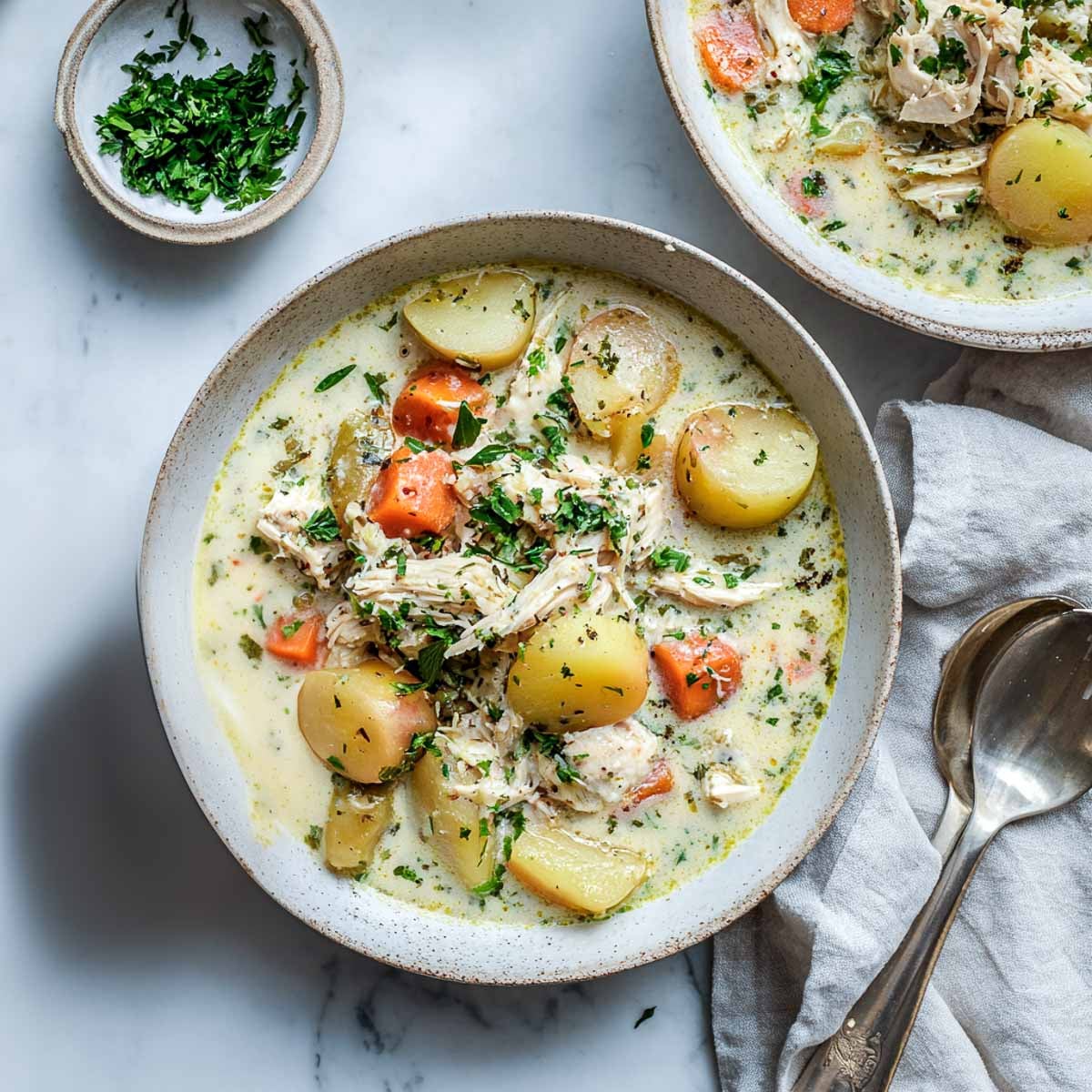 Rustic bowl of chicken stew with potatoes, carrots, and creamy broth.