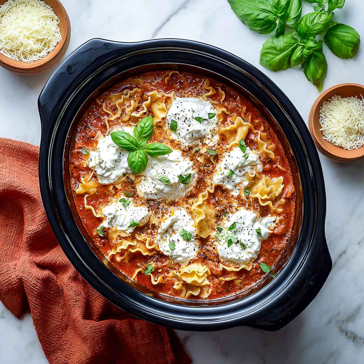 Creamy lasagna soup with ruffled noodles, cottage cheese, and basil.