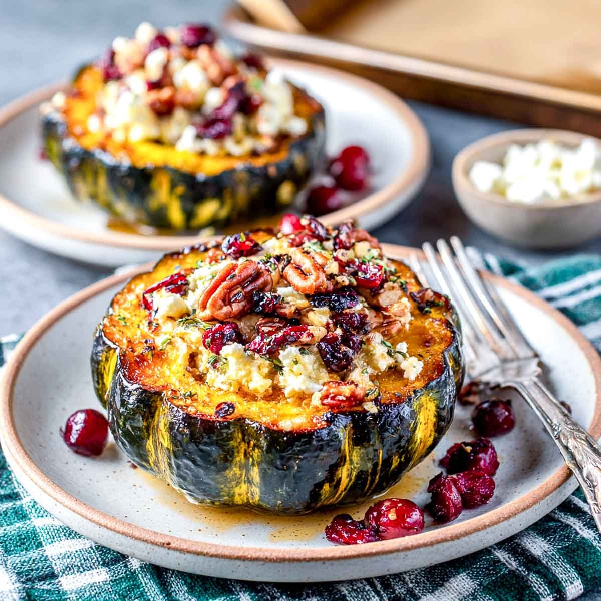 Cottage cheese stuffed acorn squash served on two plates.