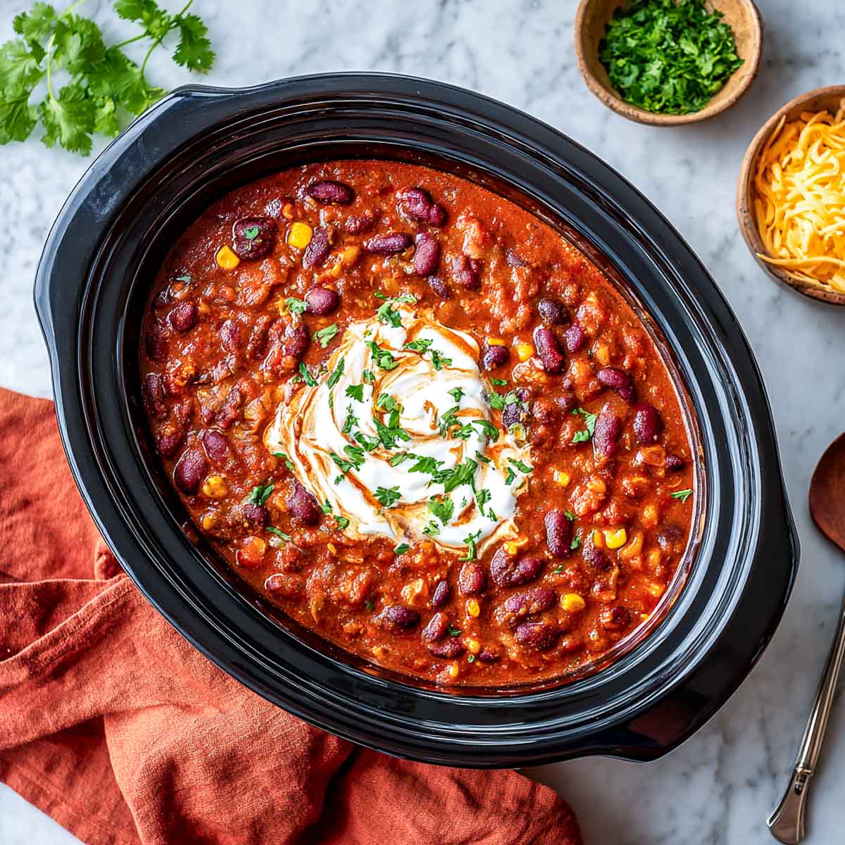 Top-down view of vegetarian chili with beans, corn, and cottage cheese topping.