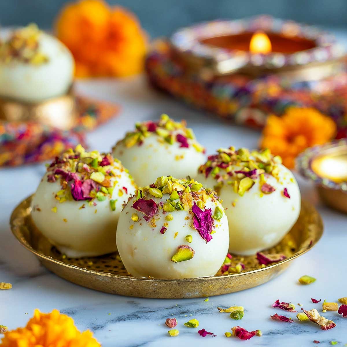 White chocolate gulab jamun truffles topped with pistachios and rose petals.
