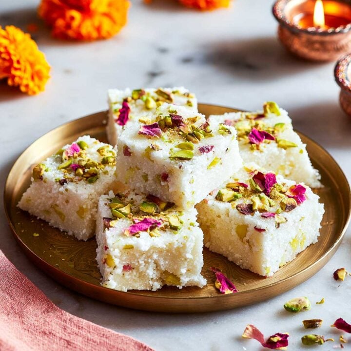 Soft and moist instant kalakand squares topped with pistachios and rose petals.