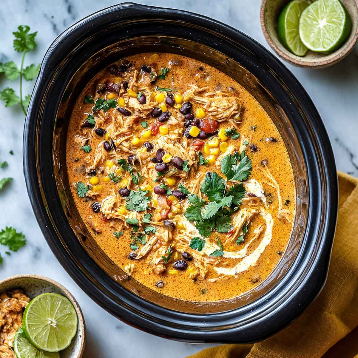 Top-down view of pumpkin chicken chili with black beans, corn, and cilantro.