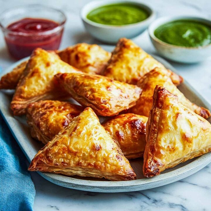 Golden samosa puffs arranged on a plate, baked until flaky and crisp.
