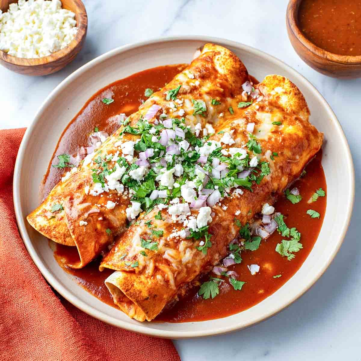 Top-down view of enchilada casserole in crockpot with melted cheese and cilantro.