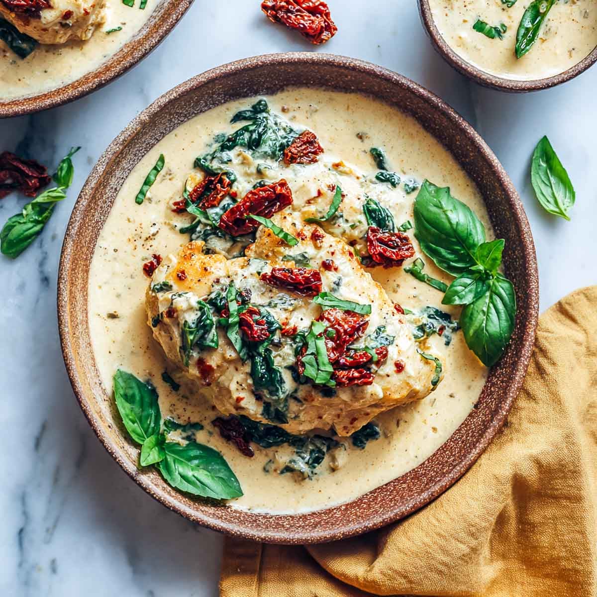 Creamy Tuscan chicken with cottage cheese sauce on rustic plate.