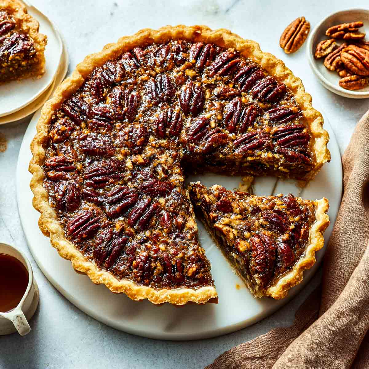 Vegan pecan pie with glossy maple filling and golden flaky crust.