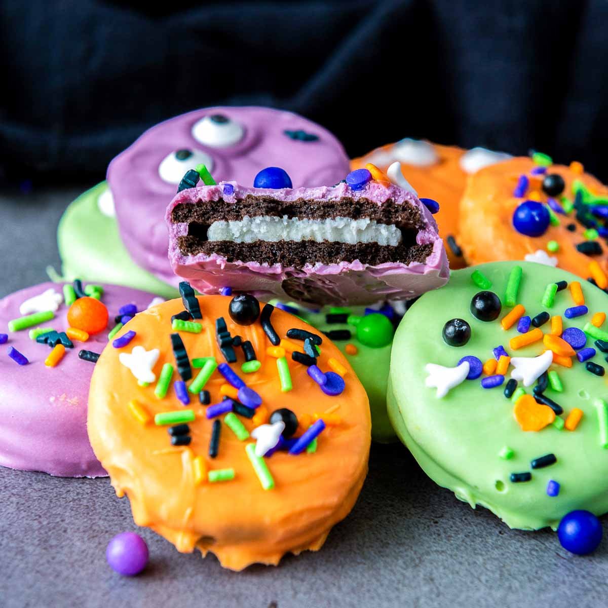 Stack of Halloween Oreos with one cut open showing creamy filling.