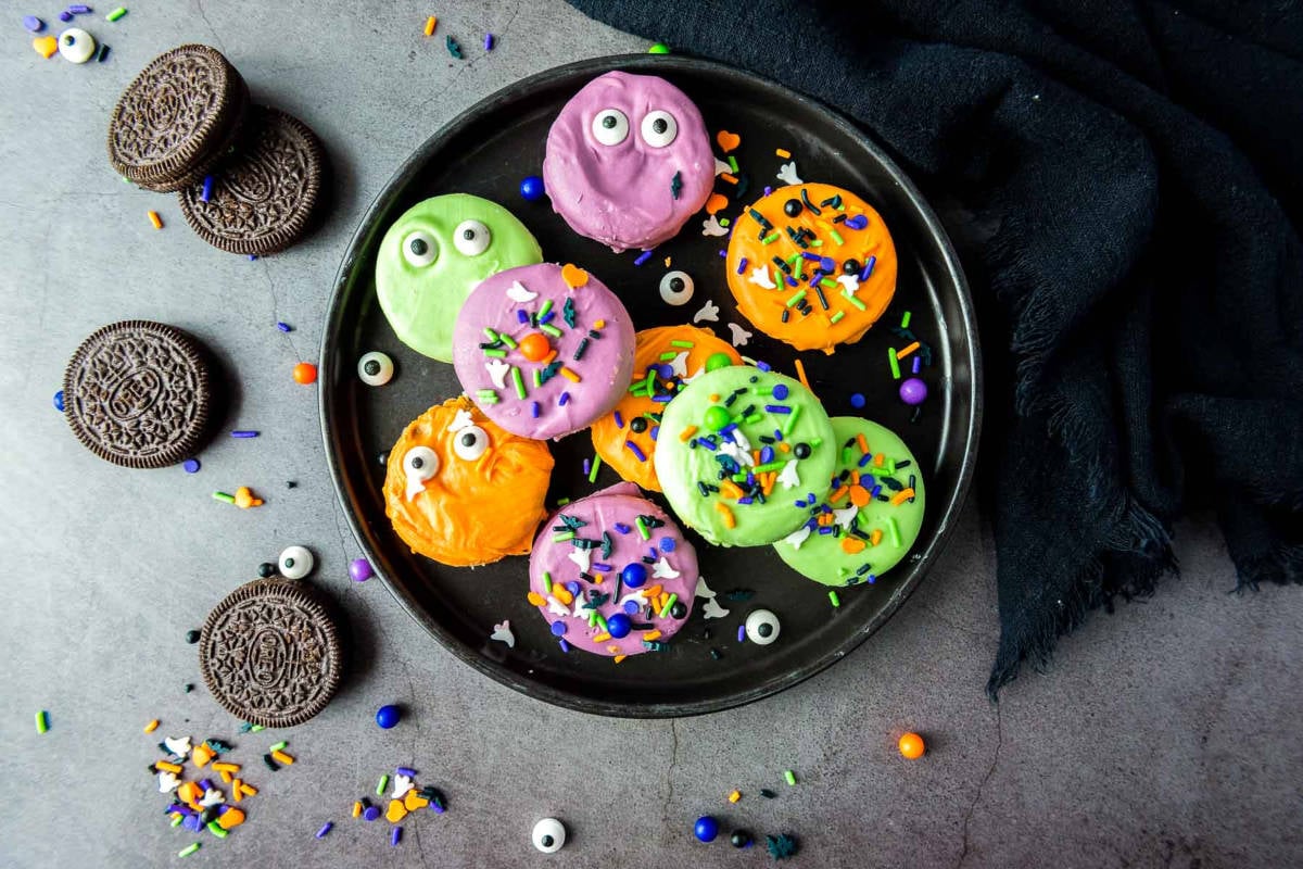Top view of Halloween Oreo cookies with sprinkles, eyes, and scattered candy.