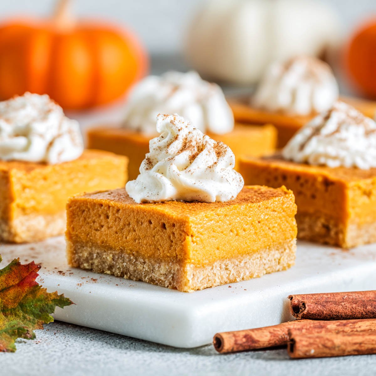 Pumpkin pie bars with a golden gluten-free crust, smooth pumpkin filling, and whipped cream topping.