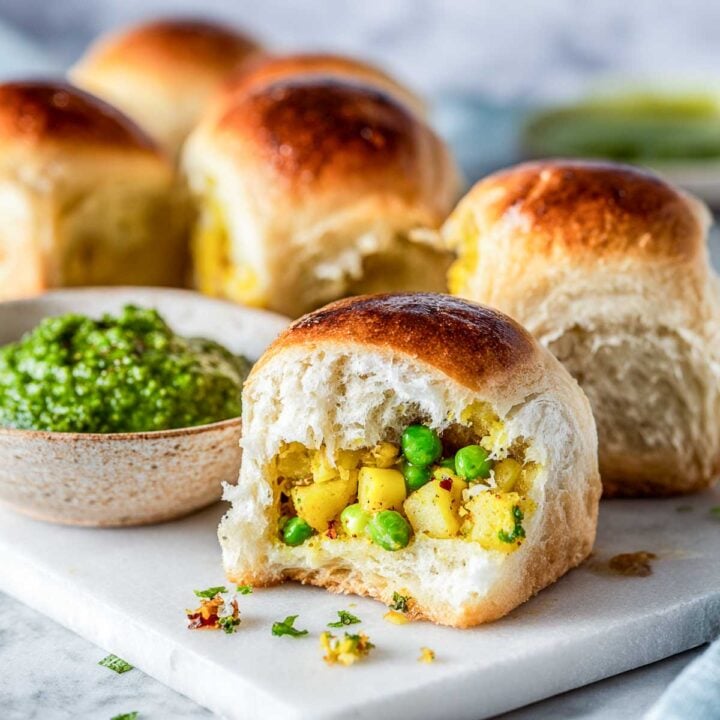 Freshly baked stuffed bread rolls with golden tops served with chutney.