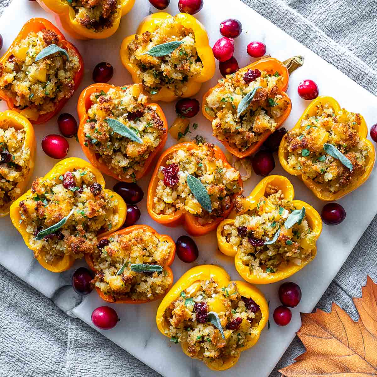 Mini bell peppers stuffed with golden-baked Thanksgiving stuffing and garnished with cranberries and sage.