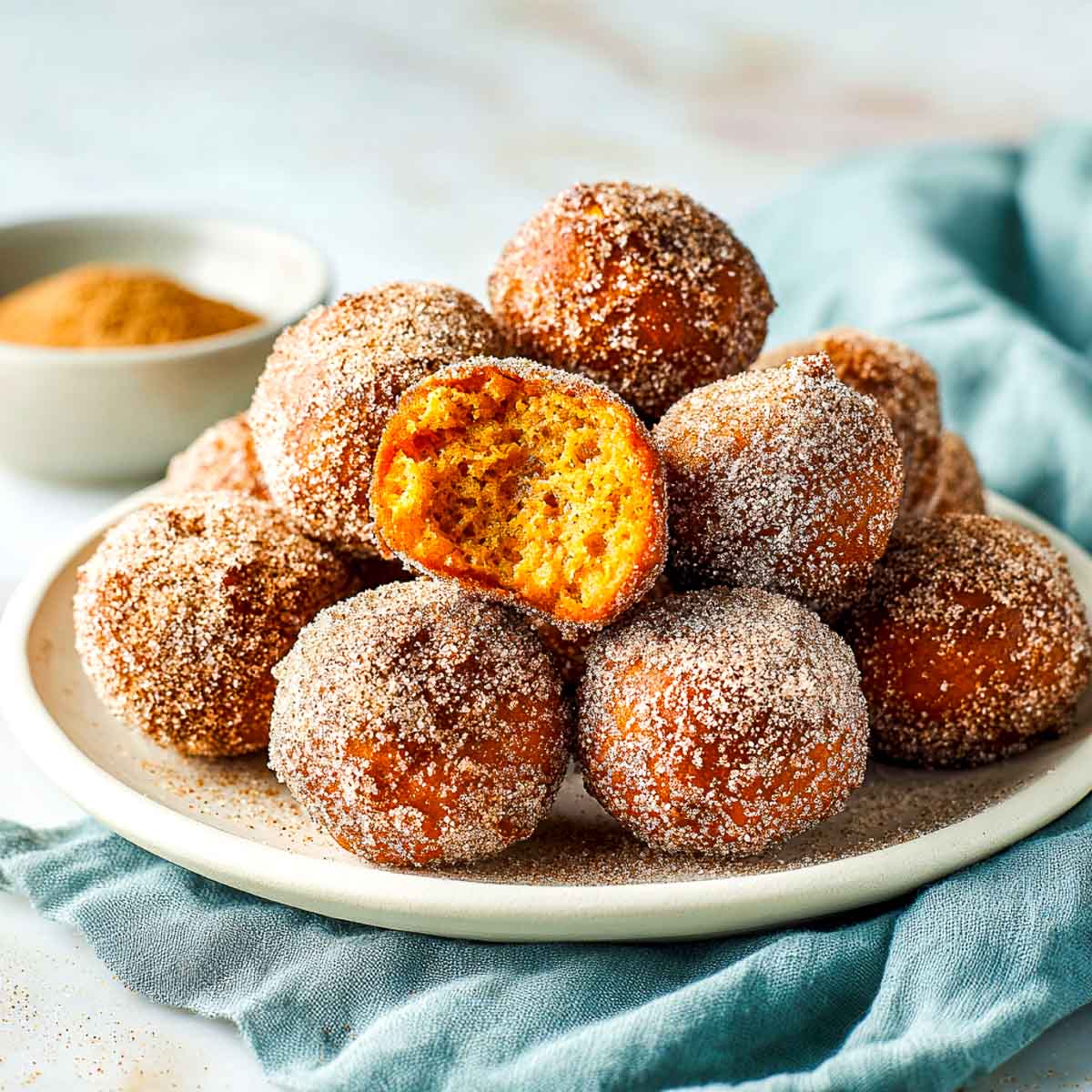 Stack of air fryer pumpkin fritters with one broken open.