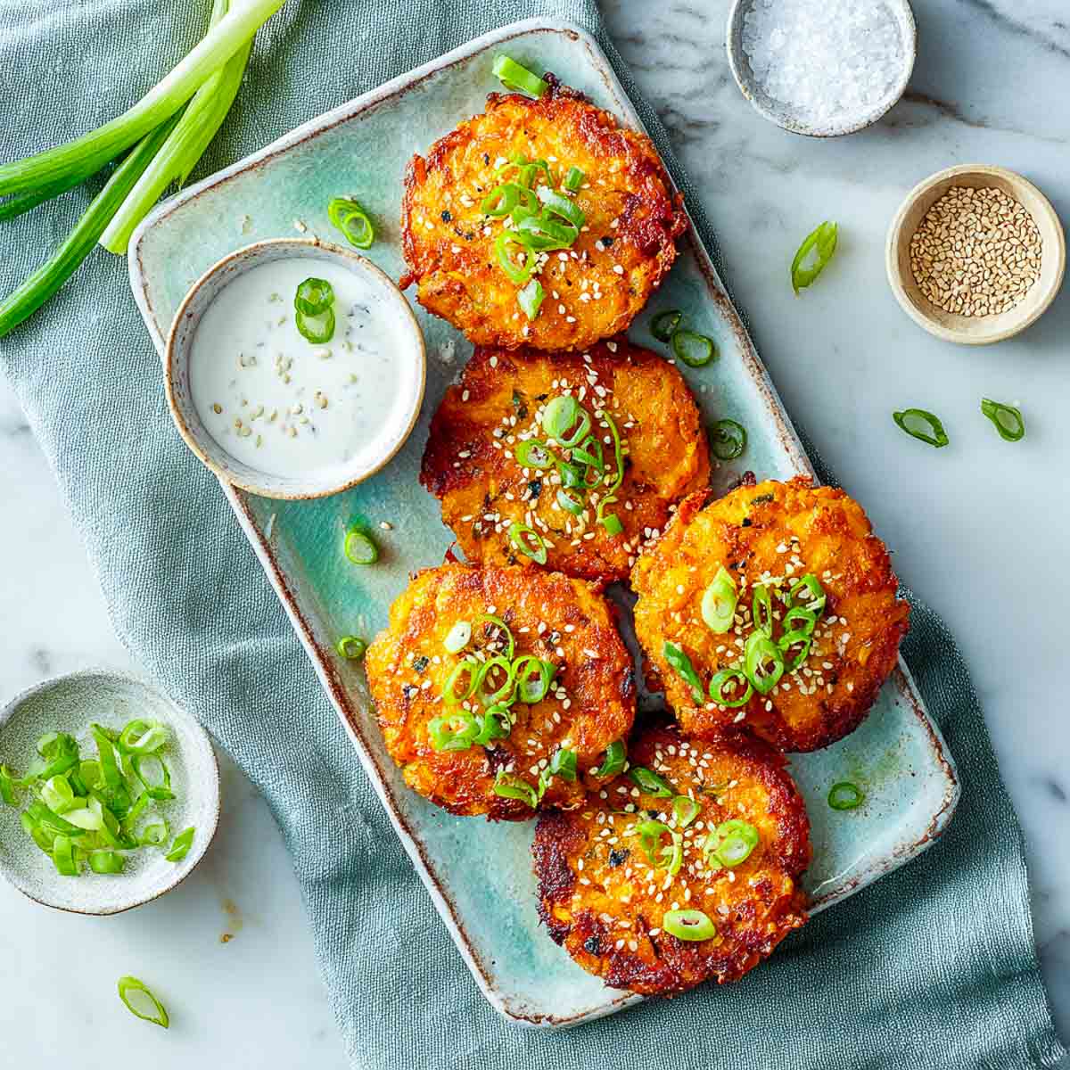 Air-fried sweet potato fritters topped with sesame seeds and green onions.